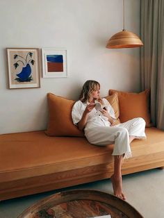 a woman sitting on top of a couch next to a window