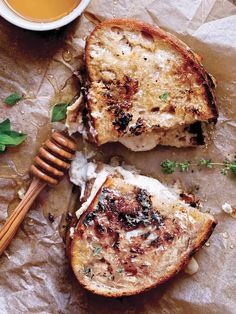 two pieces of bread with melted cheese and herbs on them next to a cup of tea