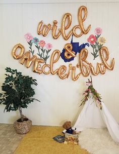 a teepee tent with balloons that say wild and wonderful