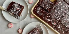 two white plates with slices of chocolate cake and peppermint sprinkles