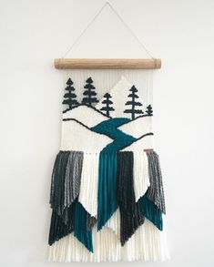 the wall hanging is decorated with green, white and black fringes that have trees on them