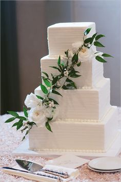 a wedding cake with white flowers and greenery