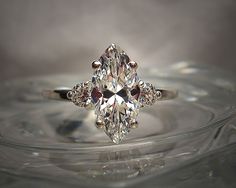 an oval cut diamond ring on top of a glass plate