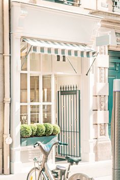 a bicycle parked next to a building on the side of the street with a planter in front of it