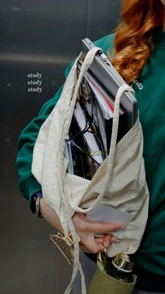 a woman with red hair carrying a bag full of files and folders in her hands