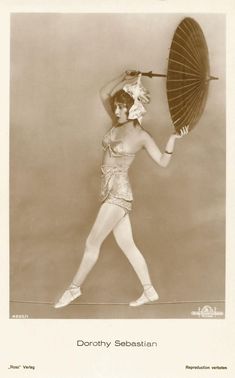 an old fashion photo of a woman holding an umbrella