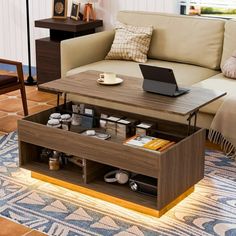 a living room with a couch, coffee table and laptop on top of the coffee table