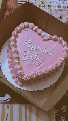 a pink heart shaped cake in a box with the words aquarius baby written on it