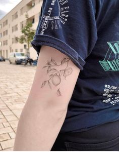 a person with a tattoo on their arm is standing in front of a brick sidewalk