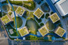 an aerial view of a city with lots of green roofing and grass growing on the roofs