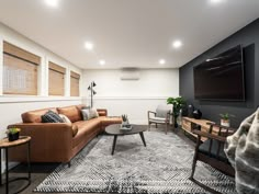 a living room filled with furniture and a flat screen tv mounted to the side of a wall