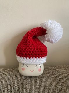 a crocheted santa hat sitting on top of a cup