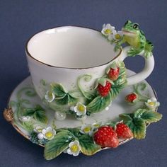 a tea cup and saucer with a frog on it