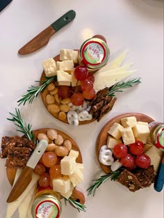 three plates with cheeses, crackers and other food items on top of them