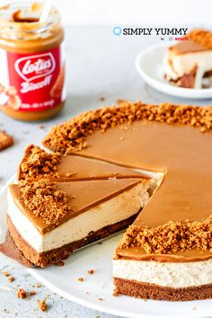 a cheesecake on a white plate with a slice taken out of it and peanut butter in the background