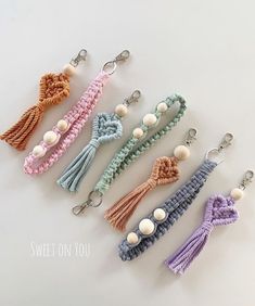 six different key chains with tassels and buttons on them, all in pastel colors