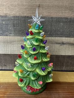 a green ceramic christmas tree on a wooden table