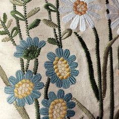 an embroidered pillow with blue and yellow flowers on it