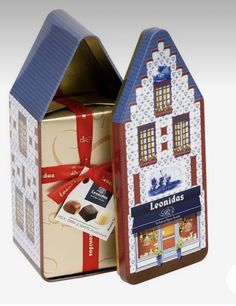 a cardboard box with a house shaped like a building and some chocolates in it