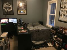 a bed room with a neatly made bed and two monitors