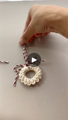 someone is making a bracelet out of yarn