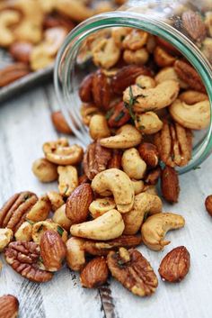 nuts spilling out of a jar on top of a wooden table