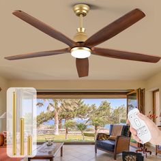 a person holding a remote control in front of a living room with a ceiling fan