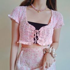 a close up of a woman wearing a pink top and skirt with lace on it