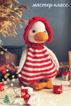 a knitted duck wearing a red and white striped dress