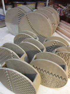 several cement bowls sitting on top of a white table next to other items in the background