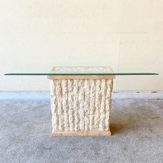 a glass table sitting on top of a carpeted floor next to a white wall