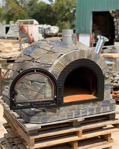 an outdoor pizza oven sitting on top of pallets