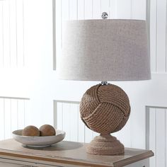 a table with a lamp and bowl on it