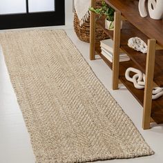 a large rug is on the floor next to a shelf with books and vases