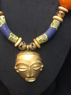 "Brass mask pendant curated with African \" bone beads & brass baule beads and ceramic beads. Perfect for casual or dressy occasion." African Inspired Jewelry, African Jewellery, Jewelry 2024, African Mask, Necklace Art, Beaded Jewelry Designs, Jewelry Essentials