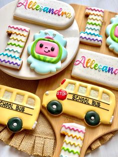 decorated cookies with school bus and nameplates are on a table next to plates