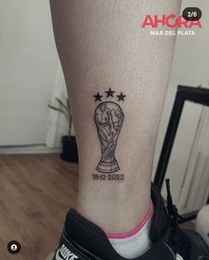 a woman's foot with a tattoo on it that has the world cup and stars