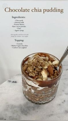 chocolate chia pudding in a glass with nuts and almonds on top, sitting on a marble countertop