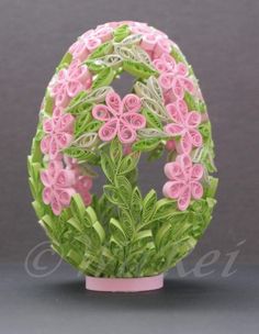 an egg decorated with pink flowers and green leaves