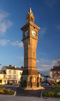 a tall clock tower sitting on the side of a road