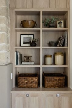 a wooden shelf with baskets and books on it