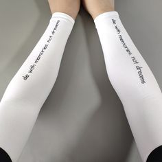 two legs wearing white socks with black writing on them and one has her hands behind her back