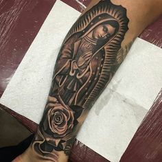 a black and white tattoo on the arm of a woman with a rose in her hand