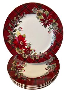 three red and white plates with poinsettis on the rim, one is empty