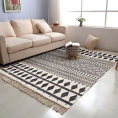 a living room filled with furniture and a large rug on the floor in front of a window