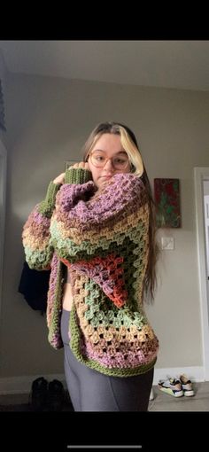 a woman wearing glasses and a crocheted sweater