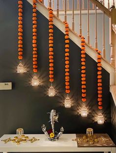 some lights that are hanging from the side of a stair case with orange balls on it