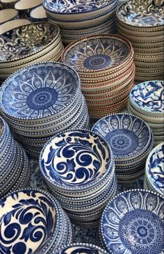 many blue and white plates stacked on top of each other