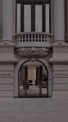 an entrance to a building with a chandelier on the top and windows above it