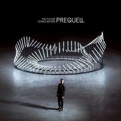 a man standing in front of a circular structure that is lit up with lights and the words presquell on it